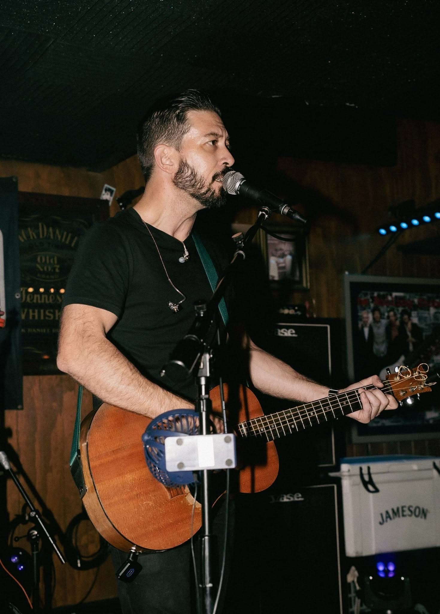 Acoustic guitarist singing on stage