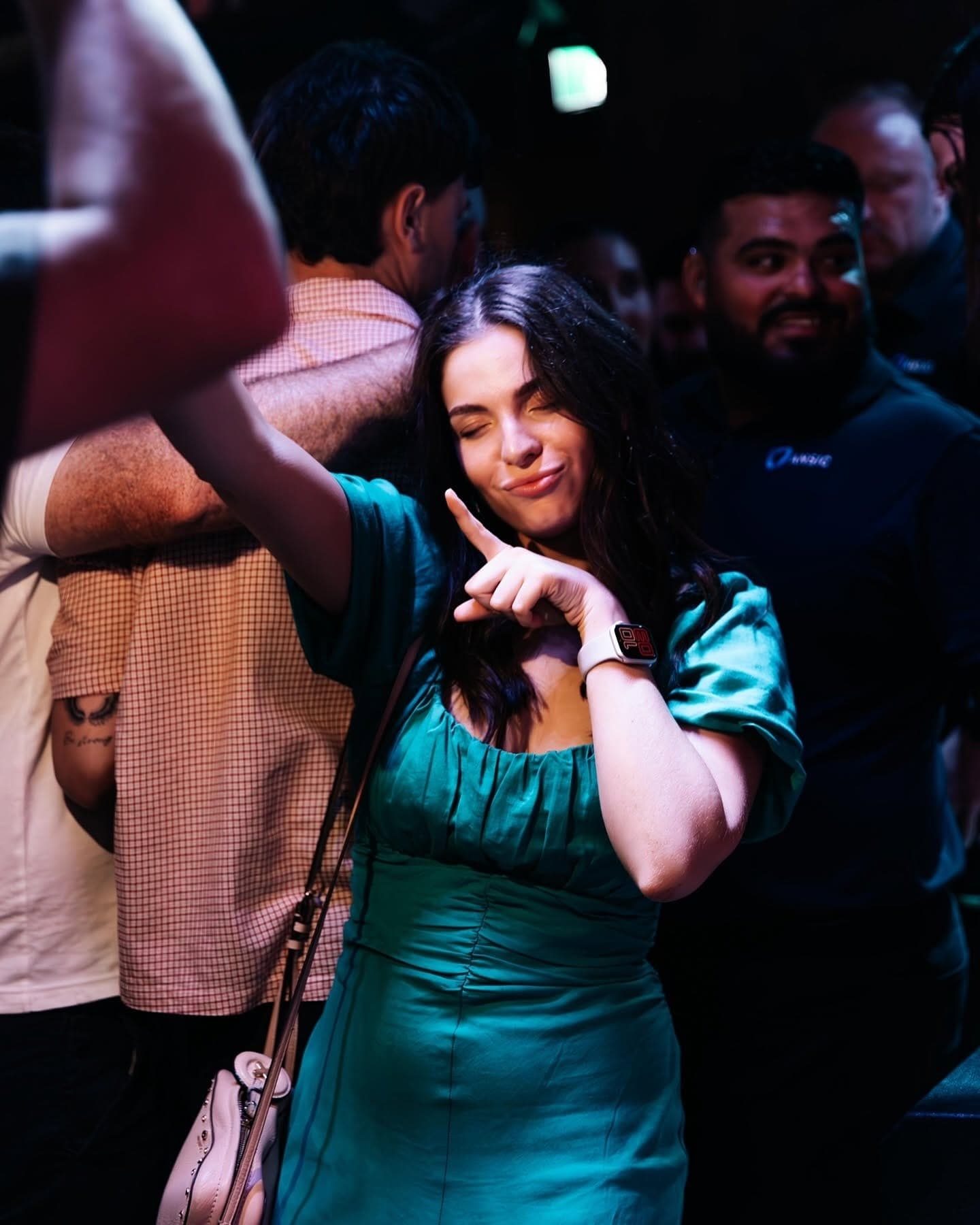 Woman in green dancing in the crowd
