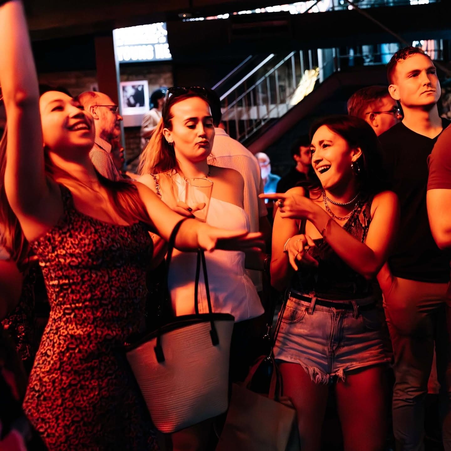 Friends singing along under red lights