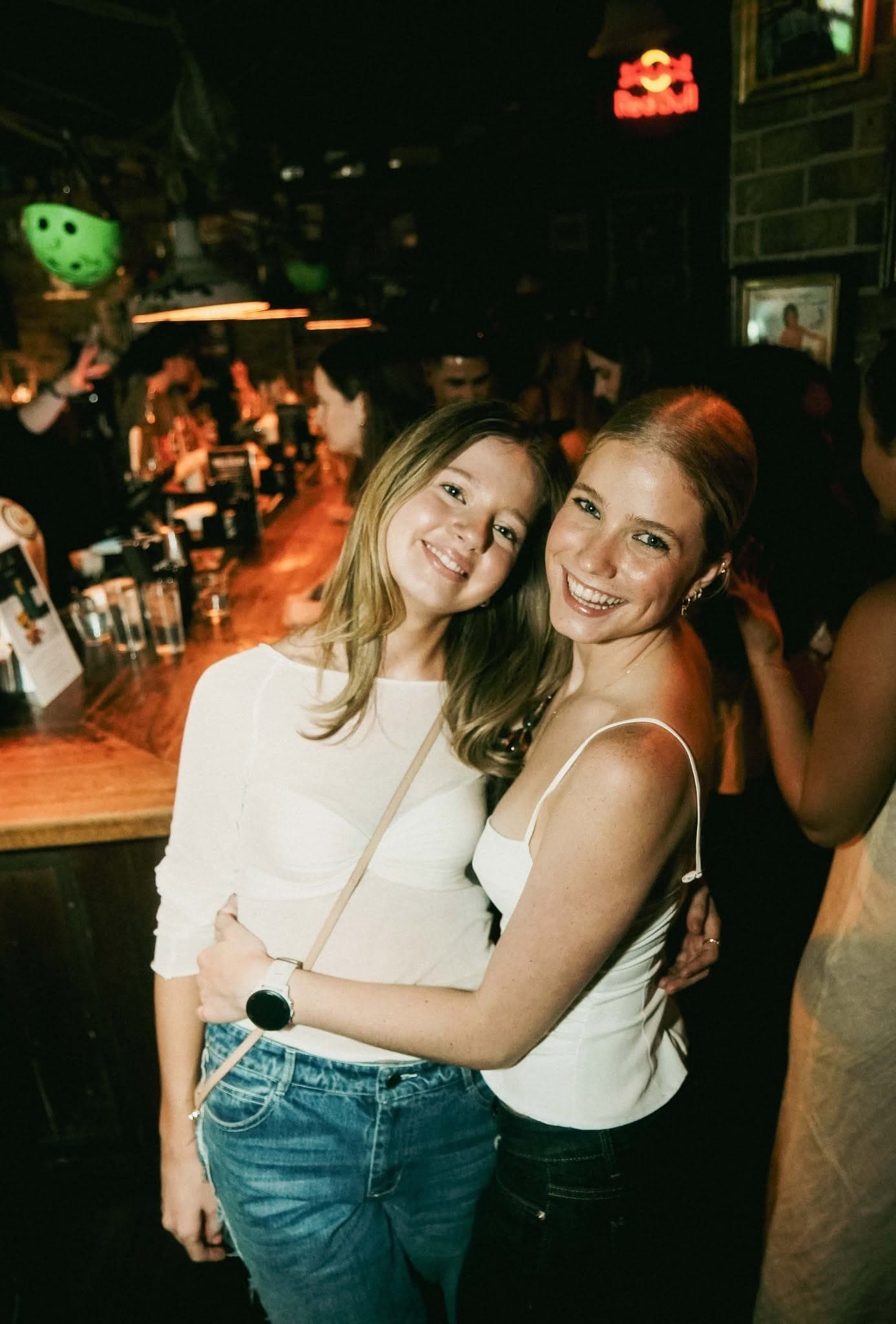Two friends hugging at the bar