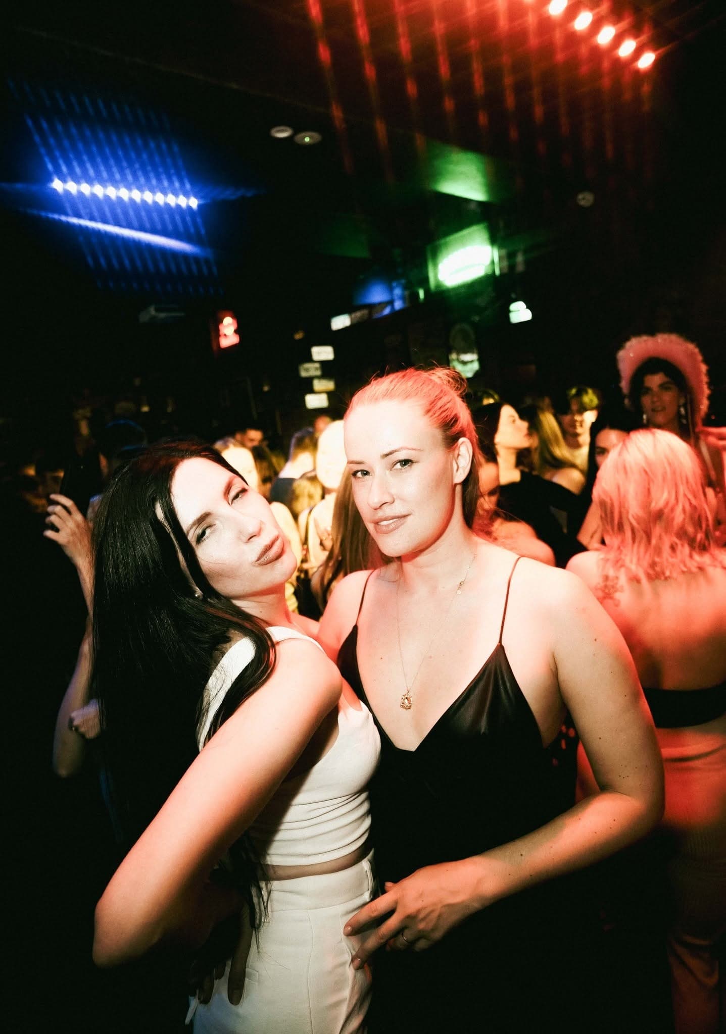 Two friends posing in the busy bar